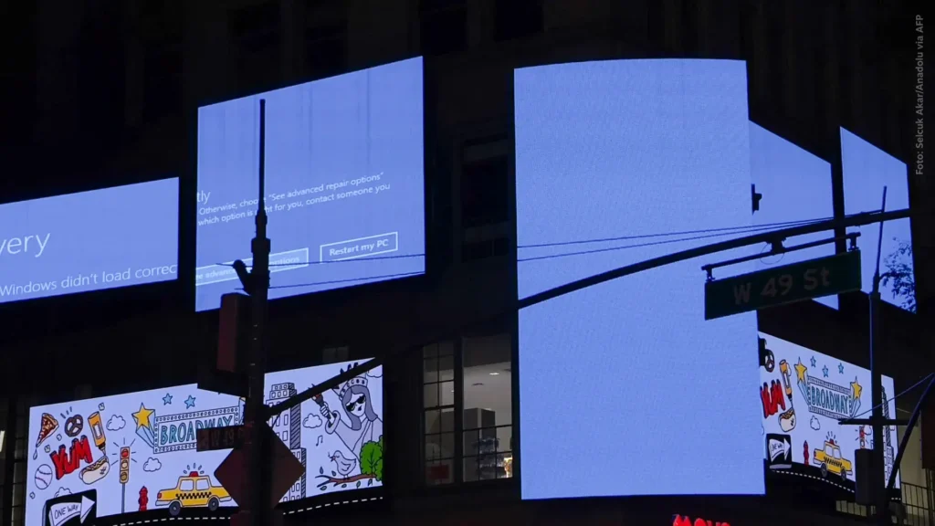 A tela azul com mensagem de erro da Microsoft nos telões da Times Square: problemas no mundo todo